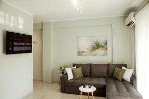 a living room with a couch and a table at Ammoshine Suite 1 in Nea Peramos