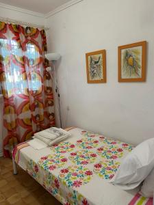 a bedroom with a bed with a flowered bedspread at 600 metres from the beach! in Nea Irakleia