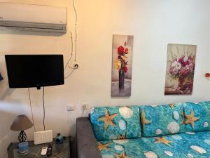 a living room with a couch and a flat screen tv at 600 metres from the beach! in Nea Irakleia