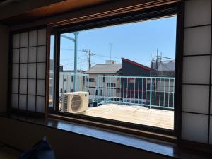 a window with a view of a balcony at 梅の宿 Umenoya 小田原城5分箱根15分城下町と温泉を愉しむ東海道の古民家ステイ PC1 in Odawara +45 photos