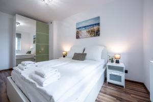 a bedroom with a large white bed and a bathroom at Apartament Lipowa 26 in Gliwice
