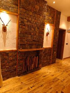 ein Raum mit einer Ziegelwand mit zwei Geweihen darauf in der Unterkunft Iris Grove in Mukteswar