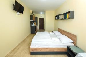 a bedroom with two beds and a tv on the wall at Maracuya Apartment in Veliko Tŭrnovo