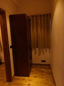 Zimmer mit Holztür und Vorhang in der Unterkunft Iris Grove in Mukteswar + 11 Fotos