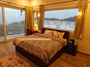 ein Schlafzimmer mit einem Bett und einem großen Fenster in der Unterkunft Iris Grove in Mukteswar