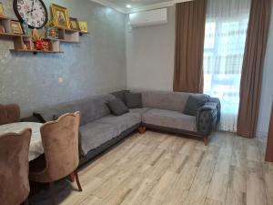 a living room with a couch and a clock on the wall at Guesthouse Toma in Gonio
