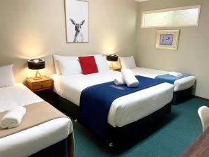 ein Hotelzimmer mit zwei Betten in einem Zimmer in der Unterkunft City Heart Motel Warrnambool in Warrnambool
