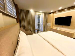 a hotel room with a bed and a flat screen tv at Lacasa De Mendez Vacation Home in Baguio