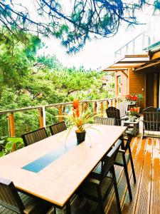 a wooden table on a deck with chairs at Lacasa De Mendez Vacation Home in Baguio