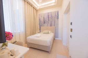 a white bedroom with a bed and a sink at Hotel Belvedere in Forte dei Marmi