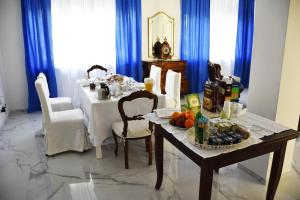 un comedor con una mesa blanca y cortinas azules en B&B Casa Nizza, en Turín