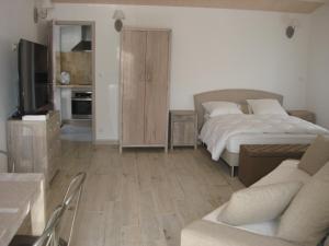a bedroom with a bed and a couch and a tv at Locations Ile de Ré in Sainte-Marie-de-Ré