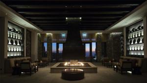 a lobby with a fireplace in the middle of a room at Alila Jabal Akhdar in Al Khuţaym