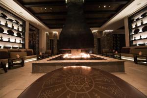 a lobby with a fireplace in the middle of a building at Alila Jabal Akhdar in Al Khuţaym