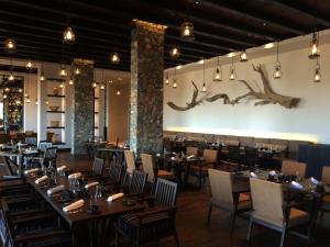 a dining room with wooden tables and chairs at Alila Jabal Akhdar in Al Khuţaym