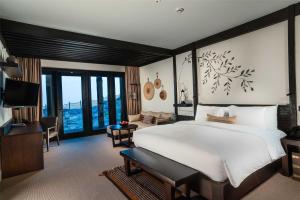 a bedroom with a large bed and a living room at Alila Jabal Akhdar in Al Khuţaym