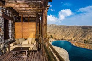 a room with a couch and a view of a pool at Alila Jabal Akhdar in Al Khuţaym