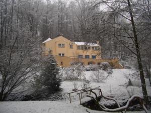a large yellow house with snow on the ground at Le Manoir De Morimont in Céroux-Mousty