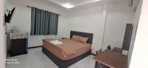 une petite chambre avec un lit et une table dans l'établissement S&P Resort บ้านบุใหญ่ ตำบลสูงเนิน อำเภอสูงเนิน, à Ban Sukhawadi