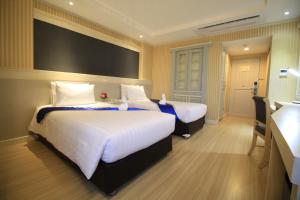 Postel nebo postele na pokoji v ubytování โรงแรมวีวิช V Wish Hotel