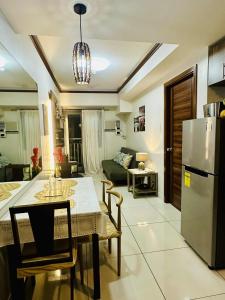 una cucina e un soggiorno con un tavolo e un frigorifero di 36T2 Chic Corner, Horizons 101, Cebu City a Cebu City