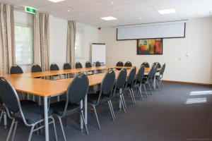 une salle de conférence avec une grande table et des chaises dans l'établissement Hotel de Stoppelberg, à Beekbergen