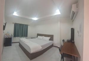 une chambre avec un lit et un bureau dans l'établissement S&P Resort บ้านบุใหญ่ ตำบลสูงเนิน อำเภอสูงเนิน, à Ban Sukhawadi 7 autres photos