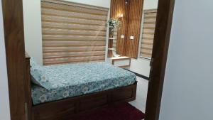 a small bed in a room with a window at Mulavarickal Homes in Nedumbassery +1 photo