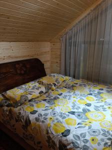 a bedroom with a bed with a floral comforter at Cottage Diamond in Dolinka