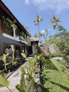 una casa con un jardín delante de ella en Indi Pixy Haven, en Gili Air