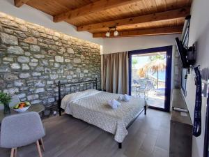 キオタリにあるParaktio Beach Apartmentsのベッドと石の壁のある寝室