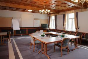 una sala conferenze con tavoli, sedie e lavagna bianca di Seehotel Schwan a Gmunden
