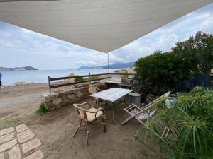 a table and chairs sitting under an umbrella on the beach at Eroico sul Mare in Portoferraio