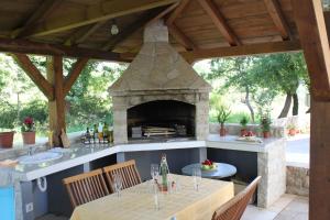 a outdoor kitchen with a stone oven and tables at Apartments Bellator in Šilo