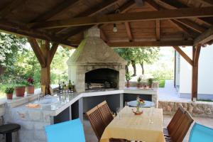 a patio with an outdoor kitchen with a stone fireplace at Apartments Bellator in Šilo