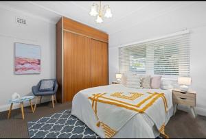a bedroom with a bed and a desk and a chair at 'Tranquil Home City, Beach, Airport' in Sydney