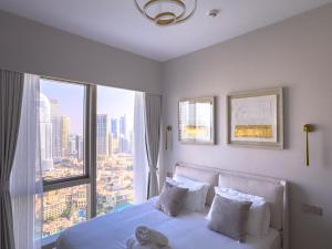 a bedroom with a bed and a large window at GRANDE RESIDENCES with a direct Burj Khalifa view and Private Fountain Show at 38th floor with DXB AIRPORT VIP Shuttle in Dubai