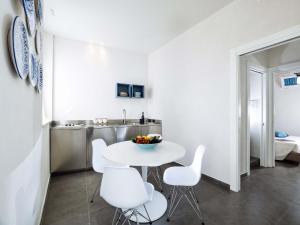 シラクーサにあるCasa Ortigiaの白いキッチン(テーブル、白い椅子付)