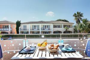 - une table avec des paniers de fruits sur un balcon dans l'établissement Résidence Odalys La Palmeraie, à Grimaud