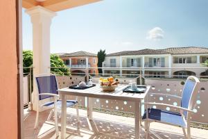 a patio with a table and chairs on a balcony at Résidence Odalys La Palmeraie in Grimaud