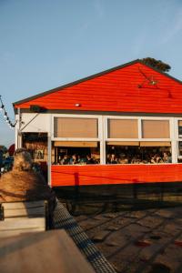 a building with a red roof with a group of people at Ostra House in Narooma +8 photos