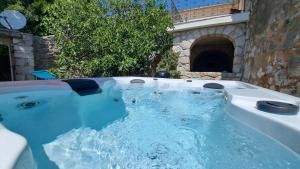 ein Whirlpool in einem Steingebäude mit Wasser in der Unterkunft Villa Bartola in Grižane