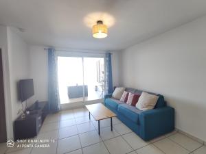 TV a/nebo společenská místnost v ubytování Le Nid Océanique ! Appart T2 avec Terrasse, Vue Mer et Parking Privé en Sous Sol, Proche du Centre Ville de Saint Gilles les Bains
