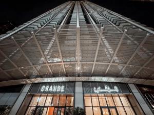 a view of a building at night with lights on at GRANDE RESIDENCES with a direct Burj Khalifa view and Private Fountain Show at 38th floor with DXB AIRPORT VIP Shuttle in Dubai +96 photos