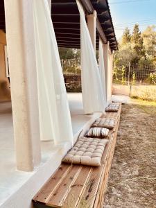 a row of pillows on a porch with curtains at Villa Depiros Corfu in Lefkimmi