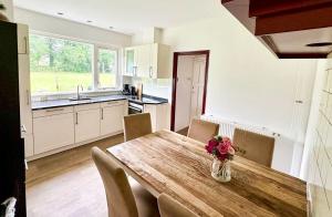 eine Küche mit einem Holztisch mit einer Vase mit Blumen darauf in der Unterkunft Vakantiewoning Het leeft in je in Hengelo