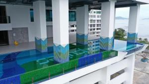 a pool on the roof of a building with columns at Bay Suites by LW in Kota Kinabalu