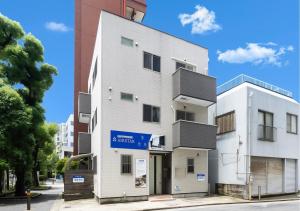 a white building with a blue sign on it at 1日1組限定の3階建て貸切宿 AIRSTAR Second in Fukuoka