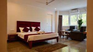 een slaapkamer met een groot bed en een woonkamer bij Heritage Suites in Mysore +9 foto's