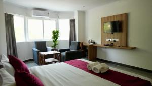 een hotelkamer met een bed en een bureau bij Heritage Suites in Mysore